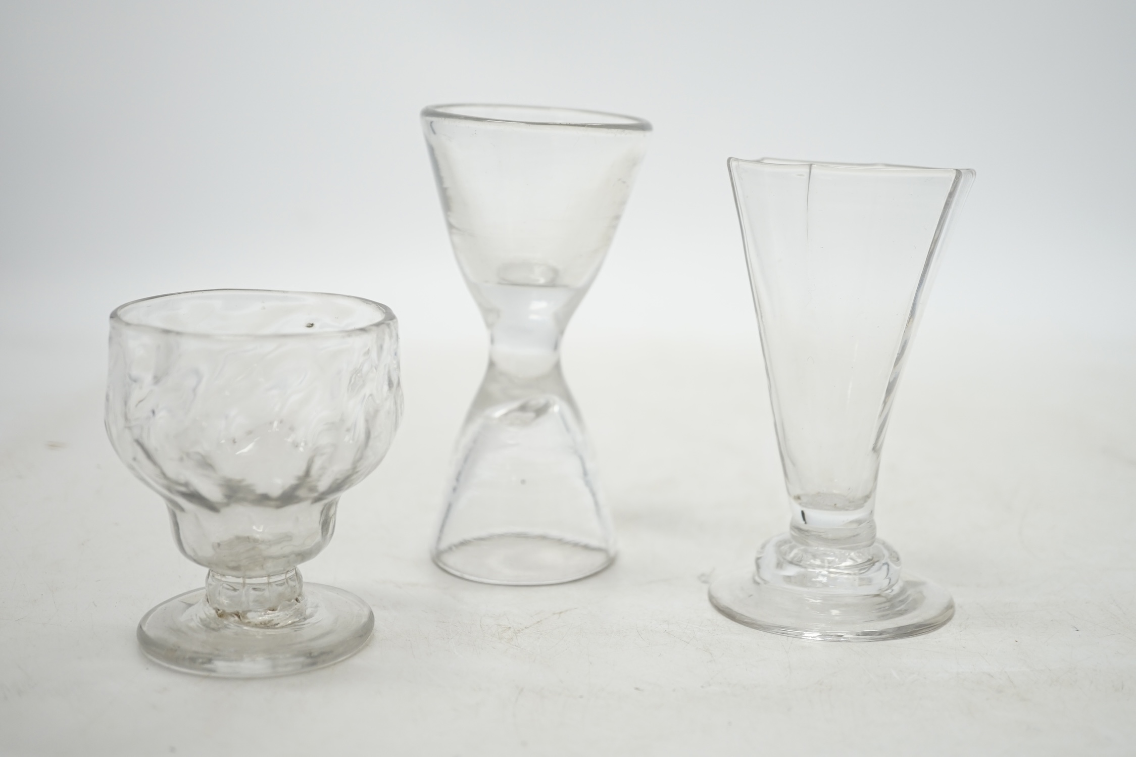 Three drinking glasses; a double ended glass, a bonnet glass and a hexagonal glass on stepped foot, tallest 11.5cm. Condition - good